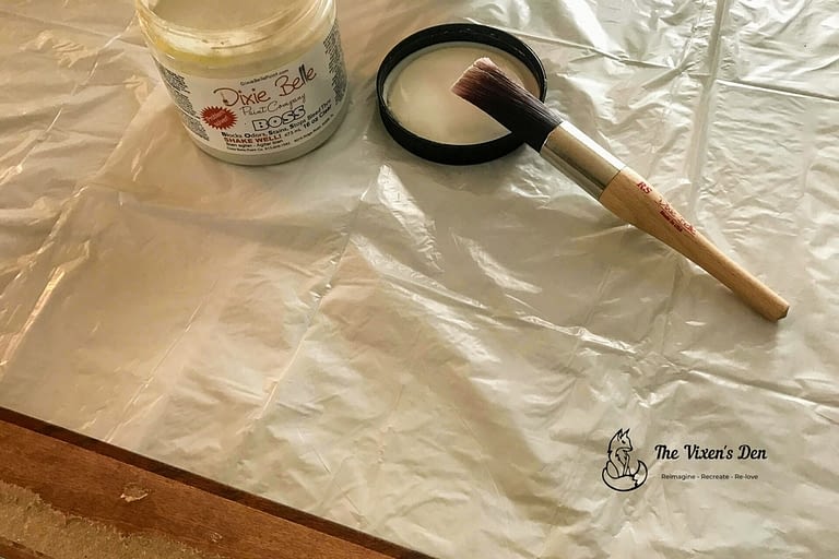 open jar of boss with a round paint brush