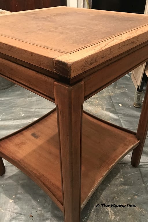 angled view of square cherry side table with repairs completed to the bottom shelf