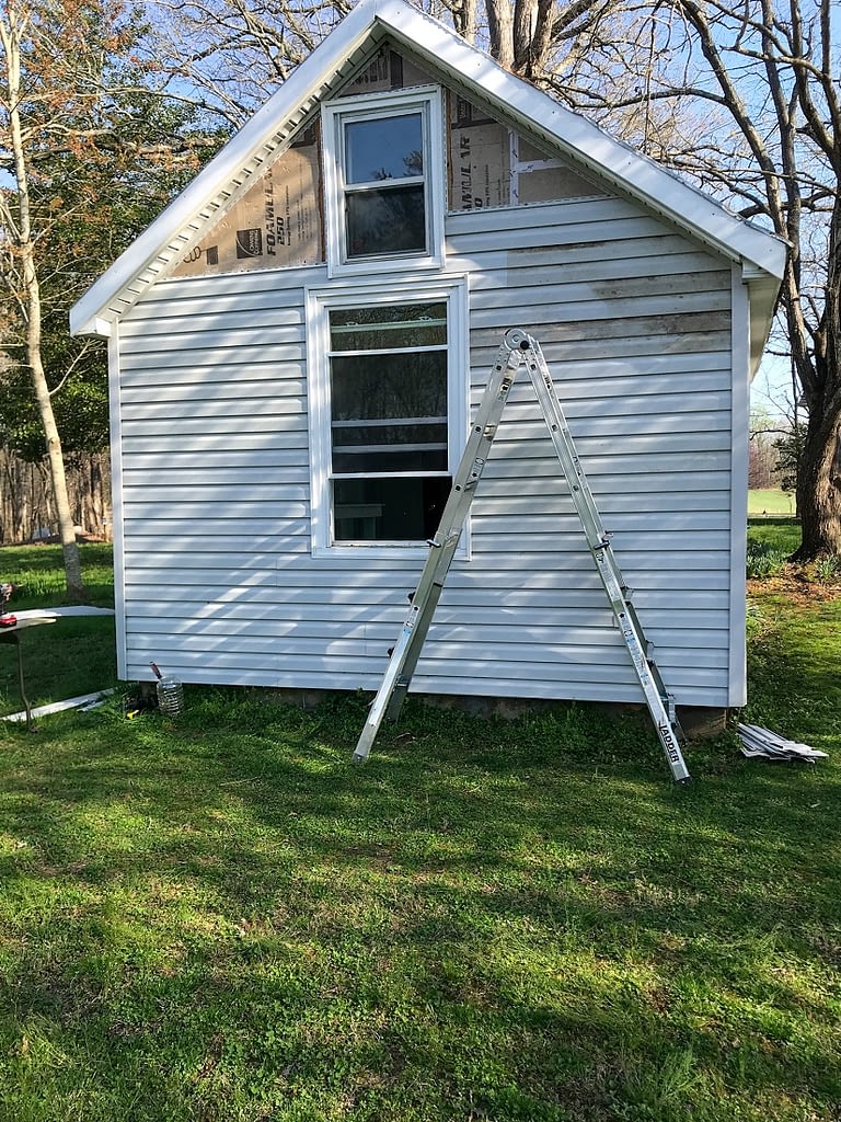 she shed with vinyl siding partially installed