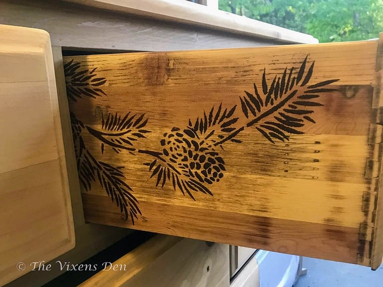 drawer side stenciled with a stained pine bough