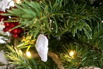 close up of a small white rock ornament hanging on a Christmas tree