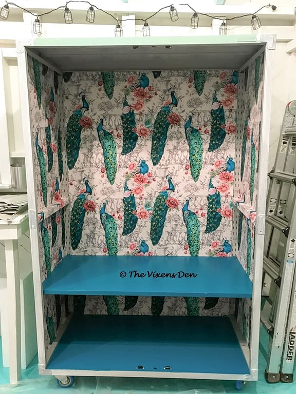 assembled metal garage cabinet, lined with peacock fabric, with first Sherwin Williams maxi teal painted shelf installed